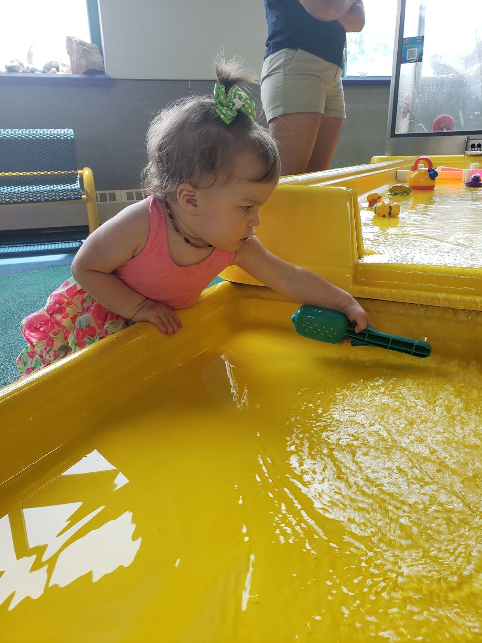 A young girl playing at a water table