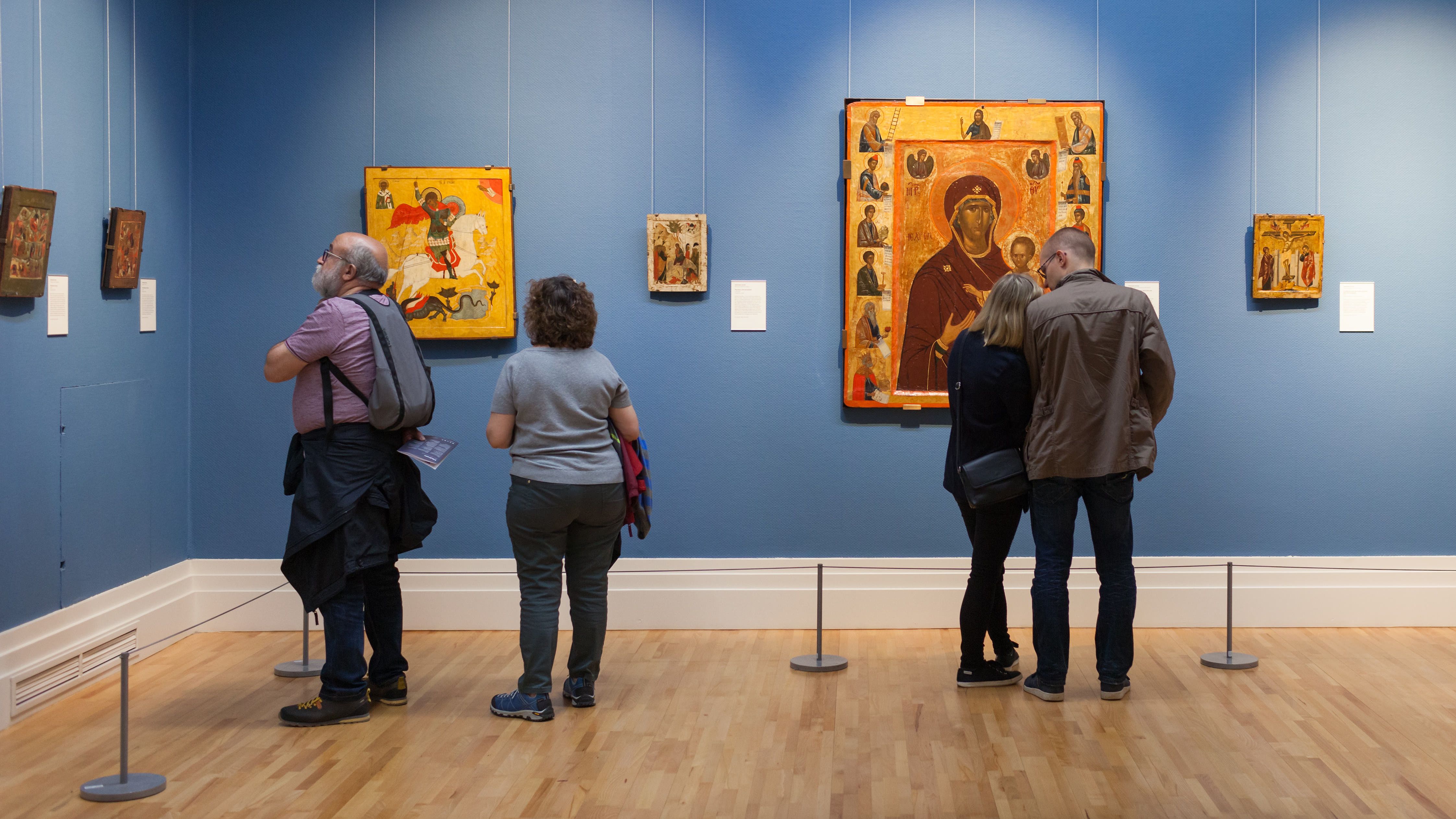 Group of people looking at different paintings inside the National Gallery of Ireland